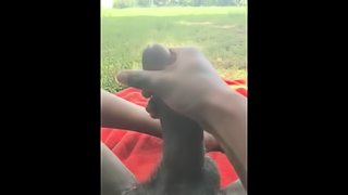 Black guy jerks off and cums outdoor laying on a blanket in the grass