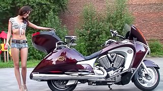 Hot chick on a motorcycle strips and plays with her tight pussy