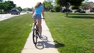 Riding a bike in her hood while wearing a tight denim skirt